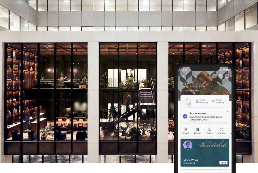 A Manhattan office tower atrium at night with a tenant tapping in on a mobile app